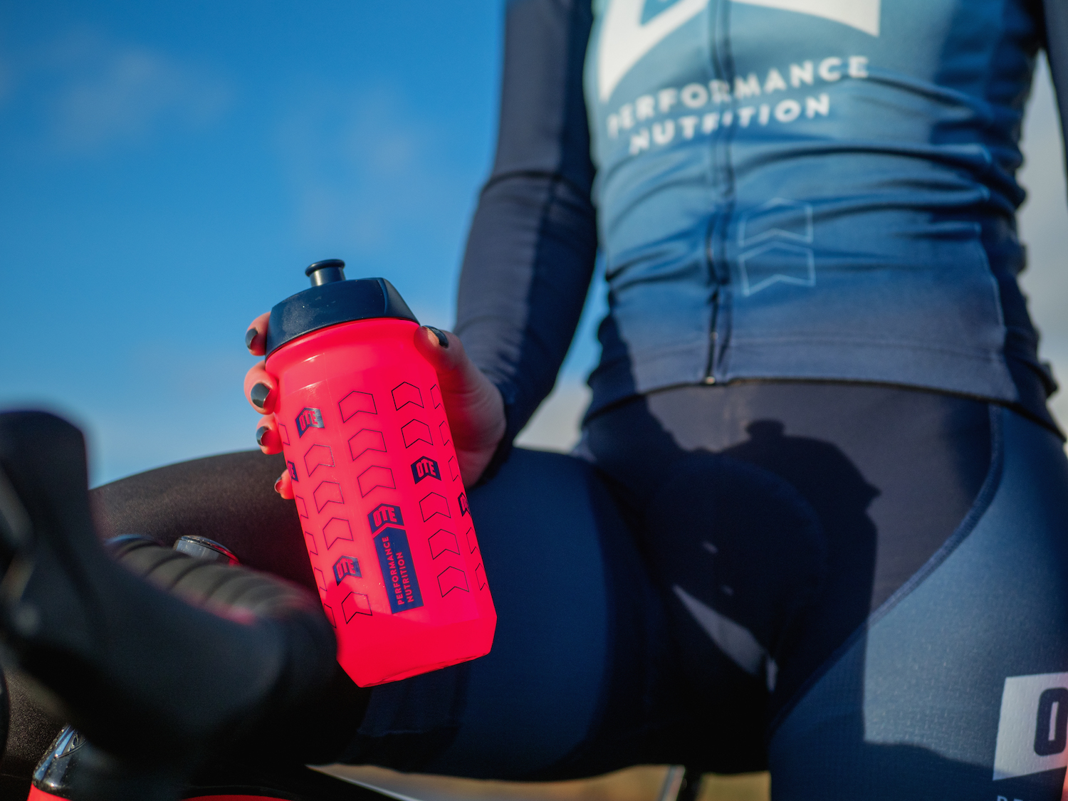 Cyclist holding pink hup hup bottle